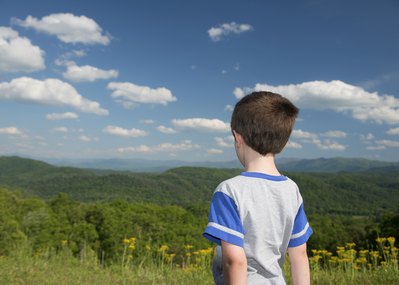 boy looks out at mountains