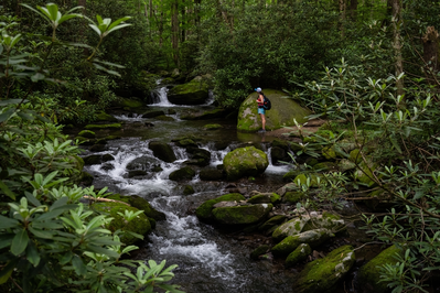 woman hiking along river in smokies